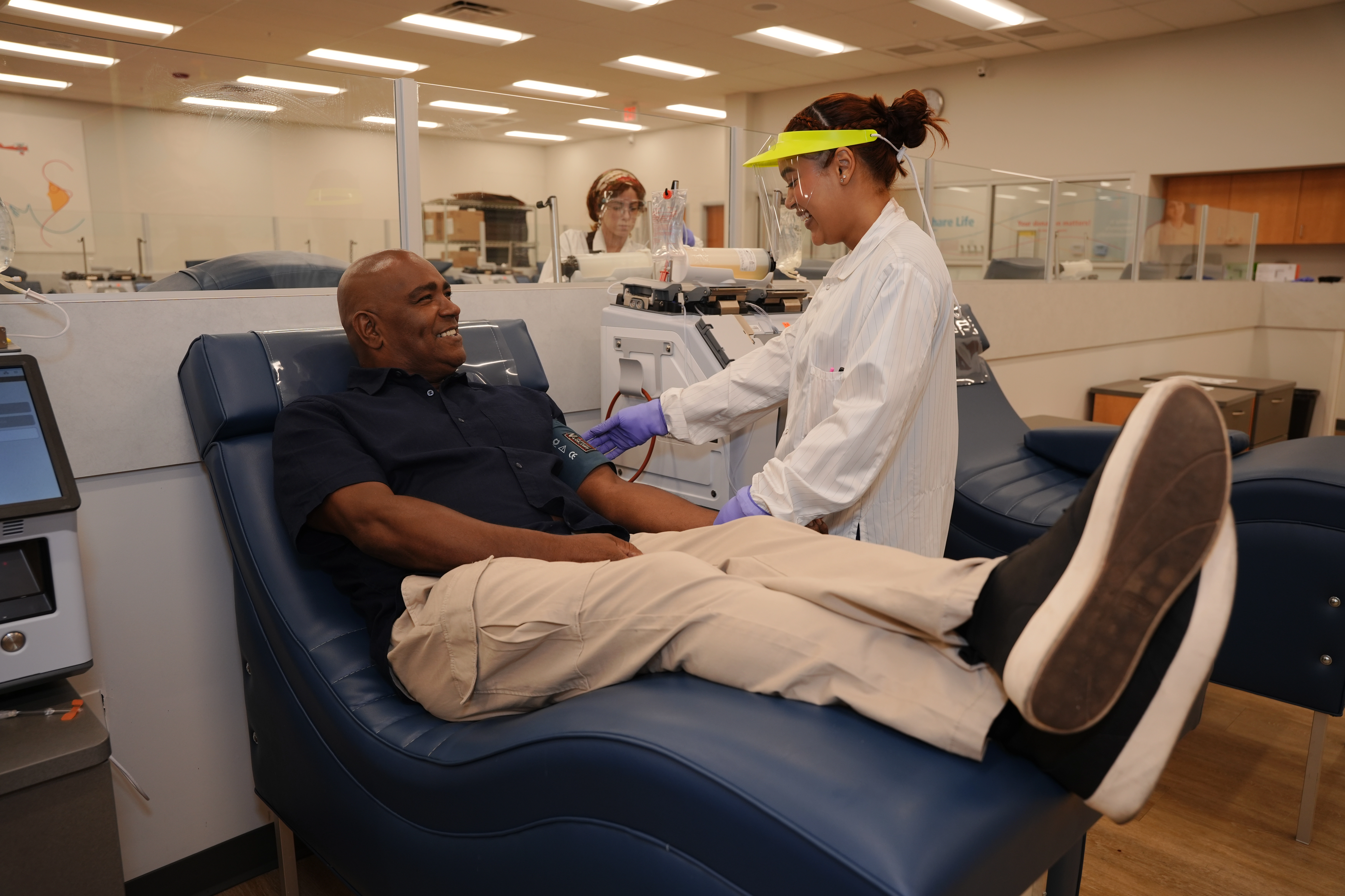 Una profesional de la salud y una mujer conversan mientras ella dona plasma.